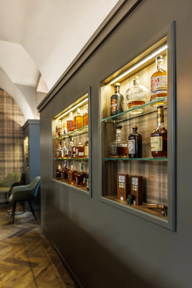 Prosklená vitrína s whisky a doutníky